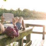 A child reading on a dock